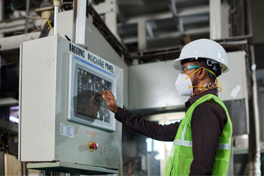 Employee working on screen of bagging machine panel at balaji formalin