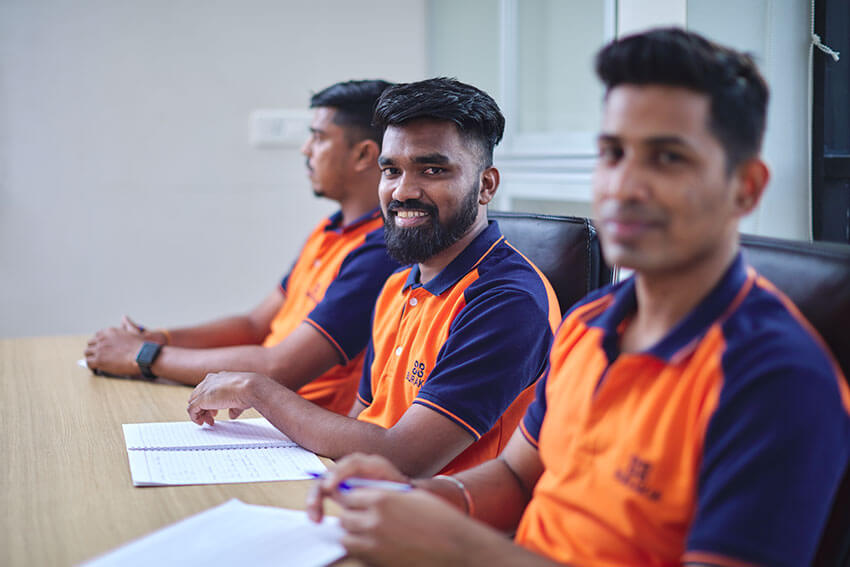 Three employees sitting with smile on desk