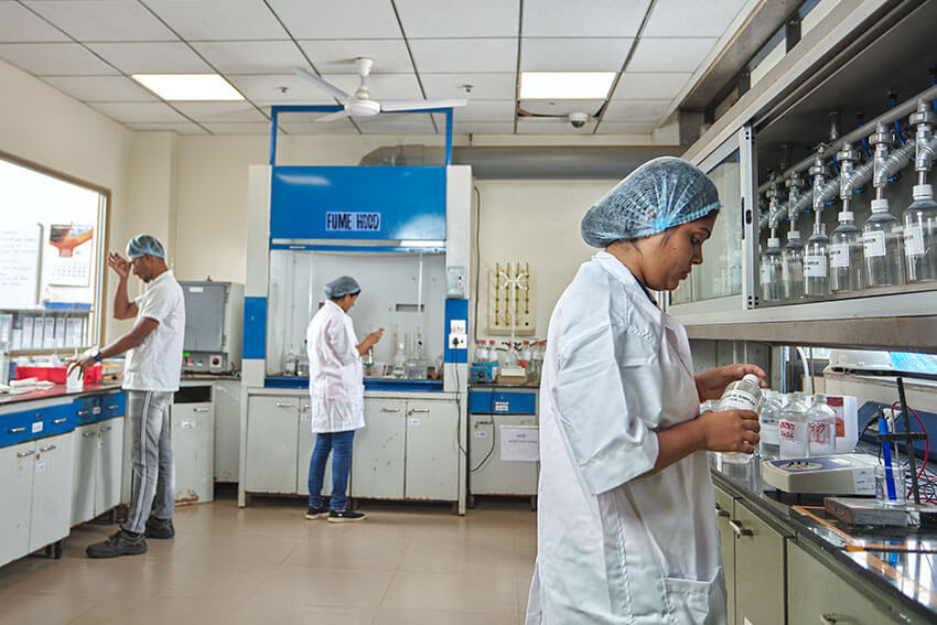 Lady worker at paraformaldehyde manufacturer Balaji Formalin lab with glass bottles 