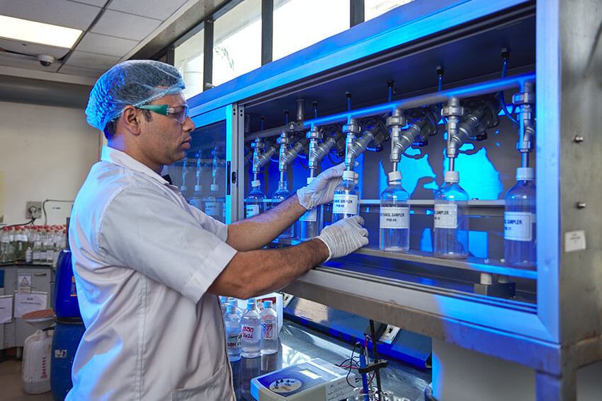 Worker checking the formaldehyde chemicals in glass tubes at Balaji Formalin