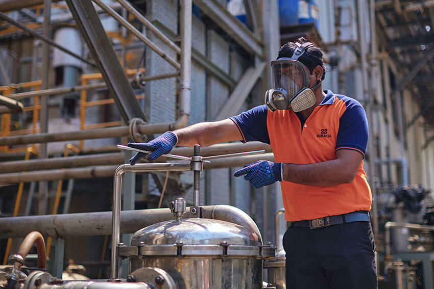 Worker in oxygen mask handling chemical tank of paraformaldehyde