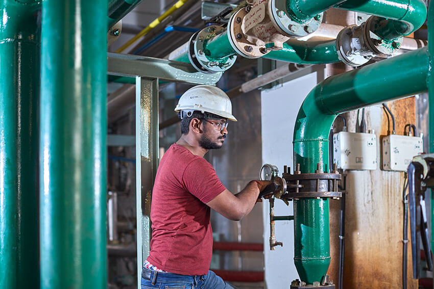 A worker at balaji formalin standing green pump pipe